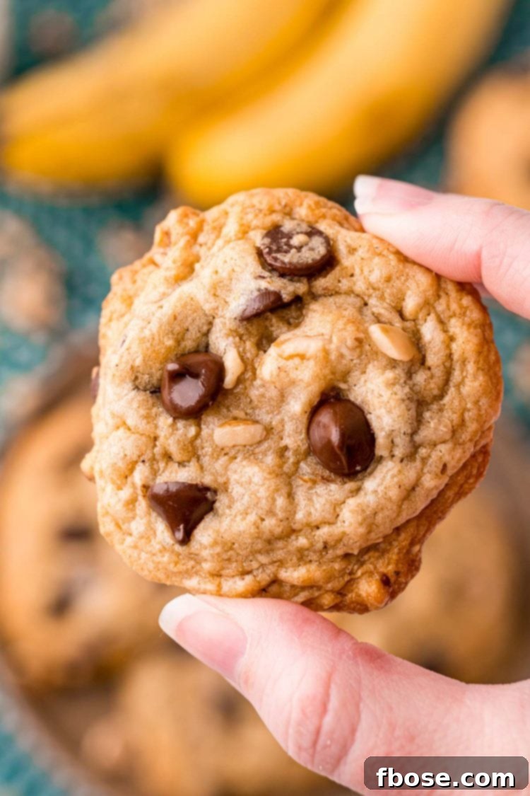 Ultimate Banana Bread Cookies 6 A woman's hand holding a banana bread cookie close to the camera.