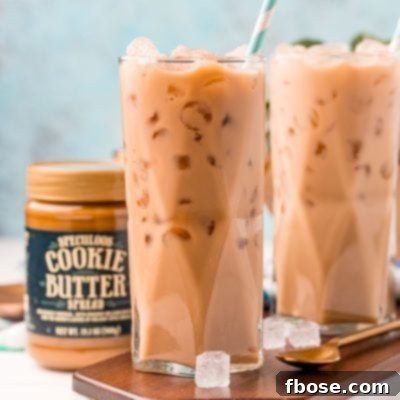 The Viral TikTok Starbucks Secret Cookie Butter Latte 7 Straight on photo of two glasses filled with iced cookie butter lattes and a jar of cookie butter next to it.