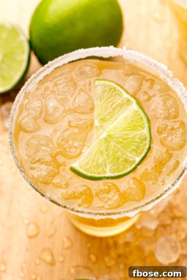 Close-up photo of a refreshing Beer Margarita, showcasing its golden hue and a lime wedge garnish, ready to be enjoyed on a warm day.