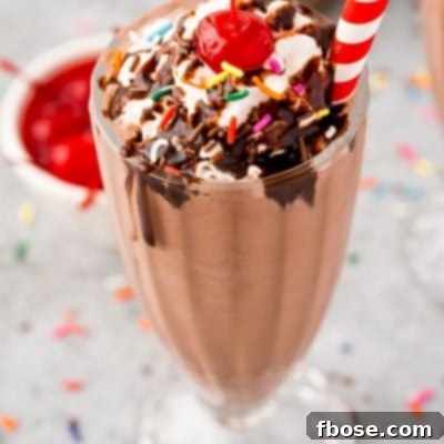 Close up photo of a chocolate milkshake, perfectly garnished and ready to enjoy.
