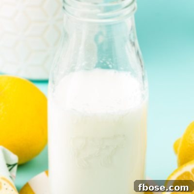 A glass milk bottle with buttermilk in it.