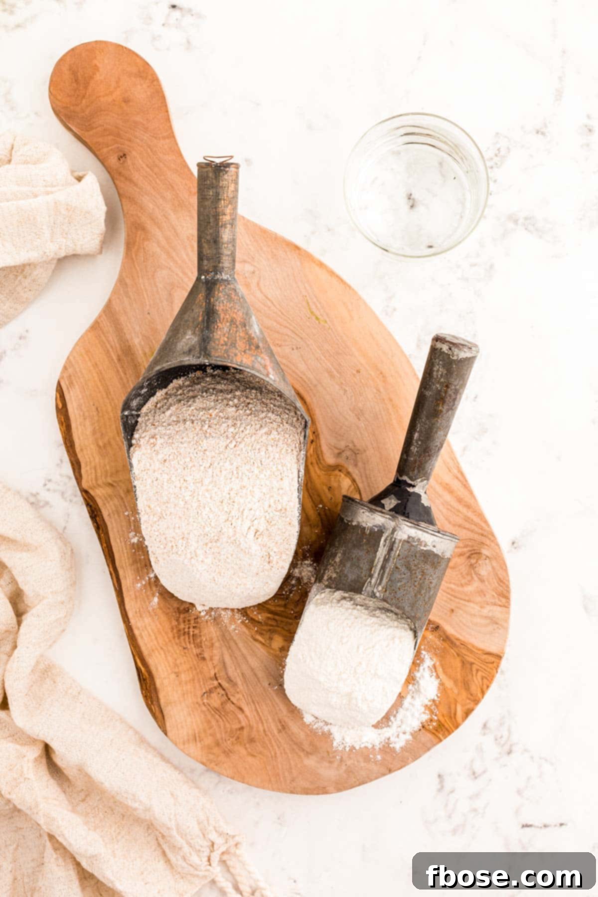 Building a Sourdough Starter 4 Ingredients to make sourdough starter on a wooden serving board.