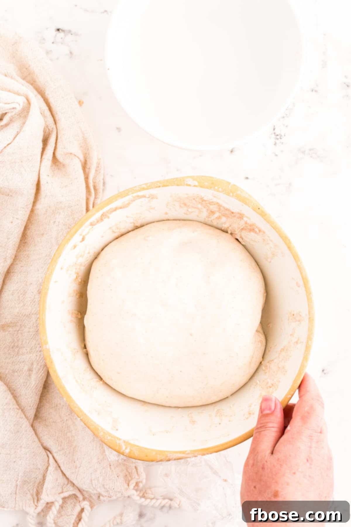 Sourdough dough in a bowl after bulk fermentation, ready for shaping, with visible air bubbles.