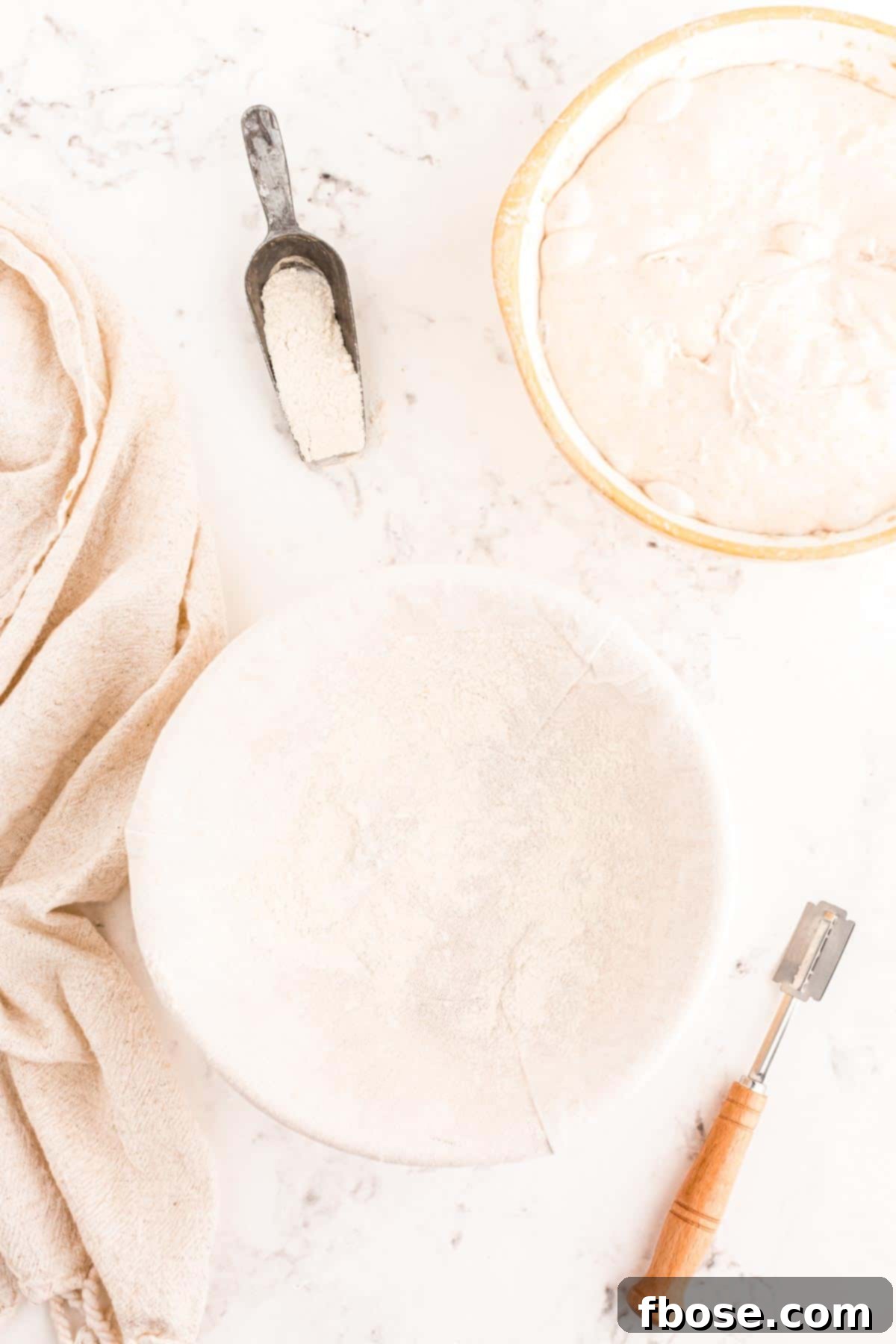 A banneton proofing basket generously dusted with rice flour, ready to receive the shaped sourdough dough.