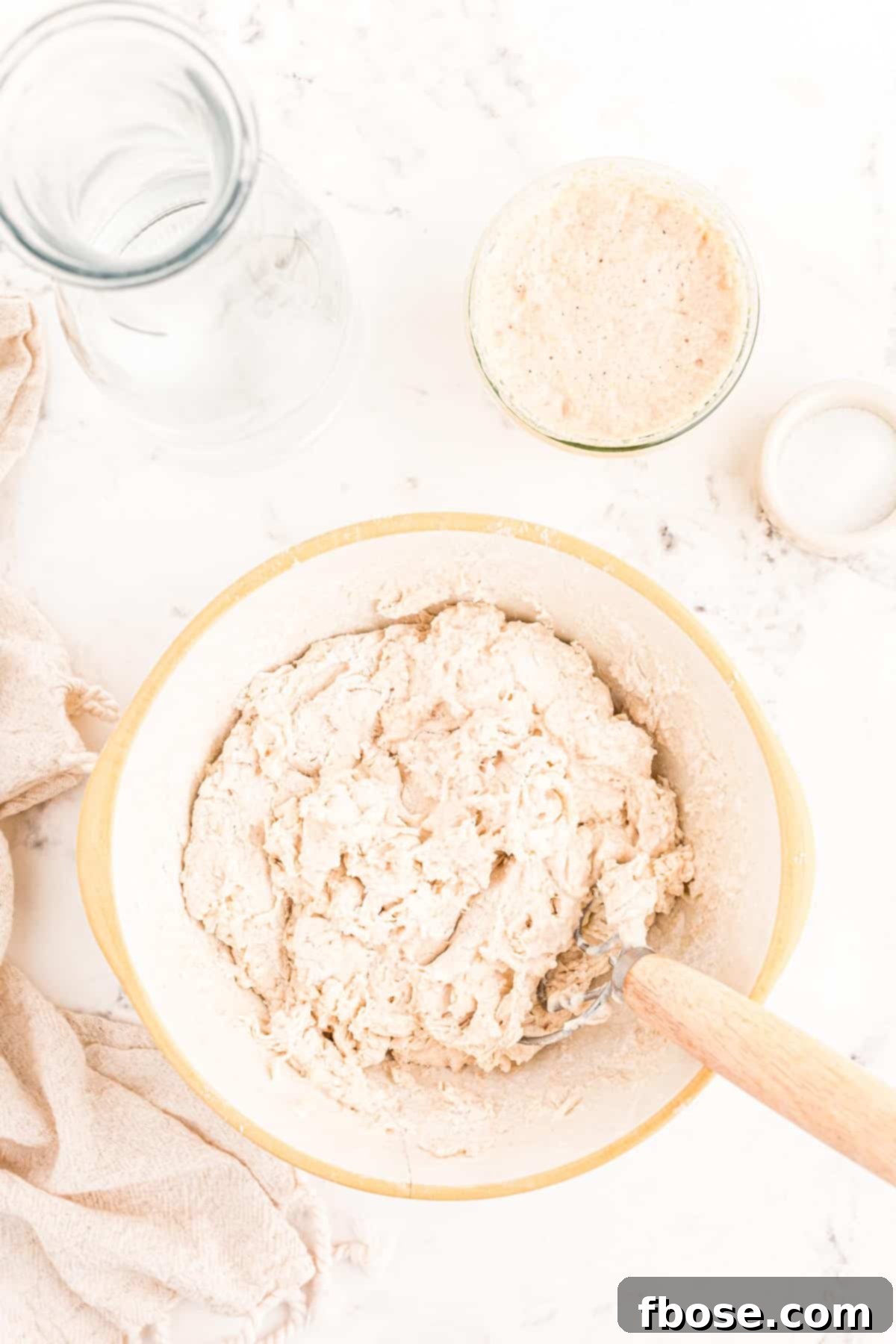 Water and flour mixed together in a bowl, appearing shaggy as it begins the autolyse process.