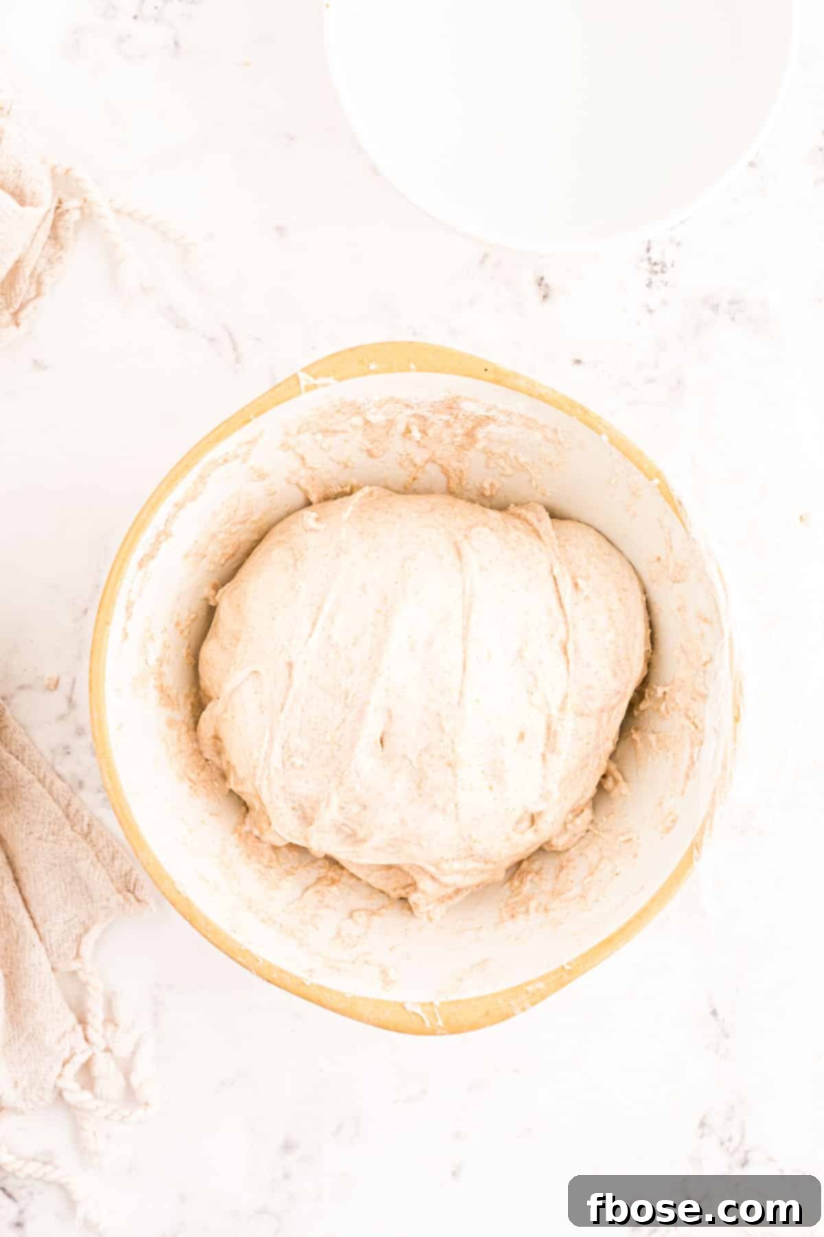 Sourdough dough after its first set of stretch and folds, resting in the bowl, visibly smoother.