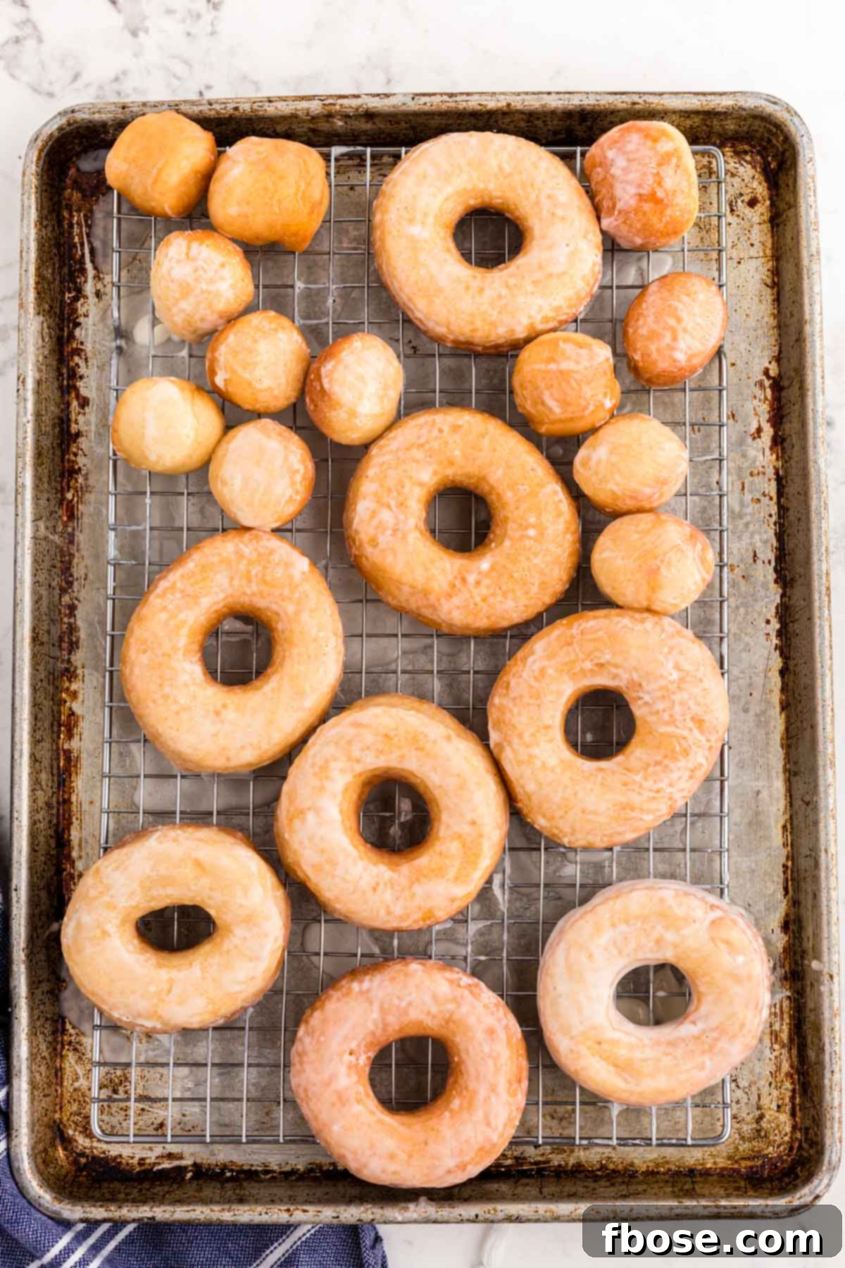 Sourdough donuts on a wire rack on a baking sheet.