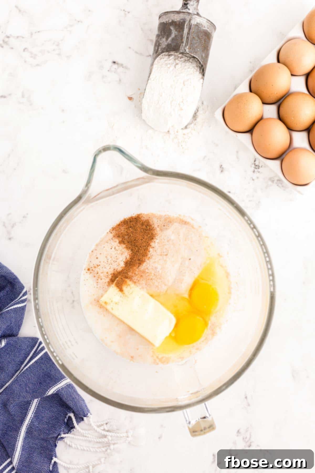 Butter, eggs, and cinnamon added to a bloomed yeast mixture.