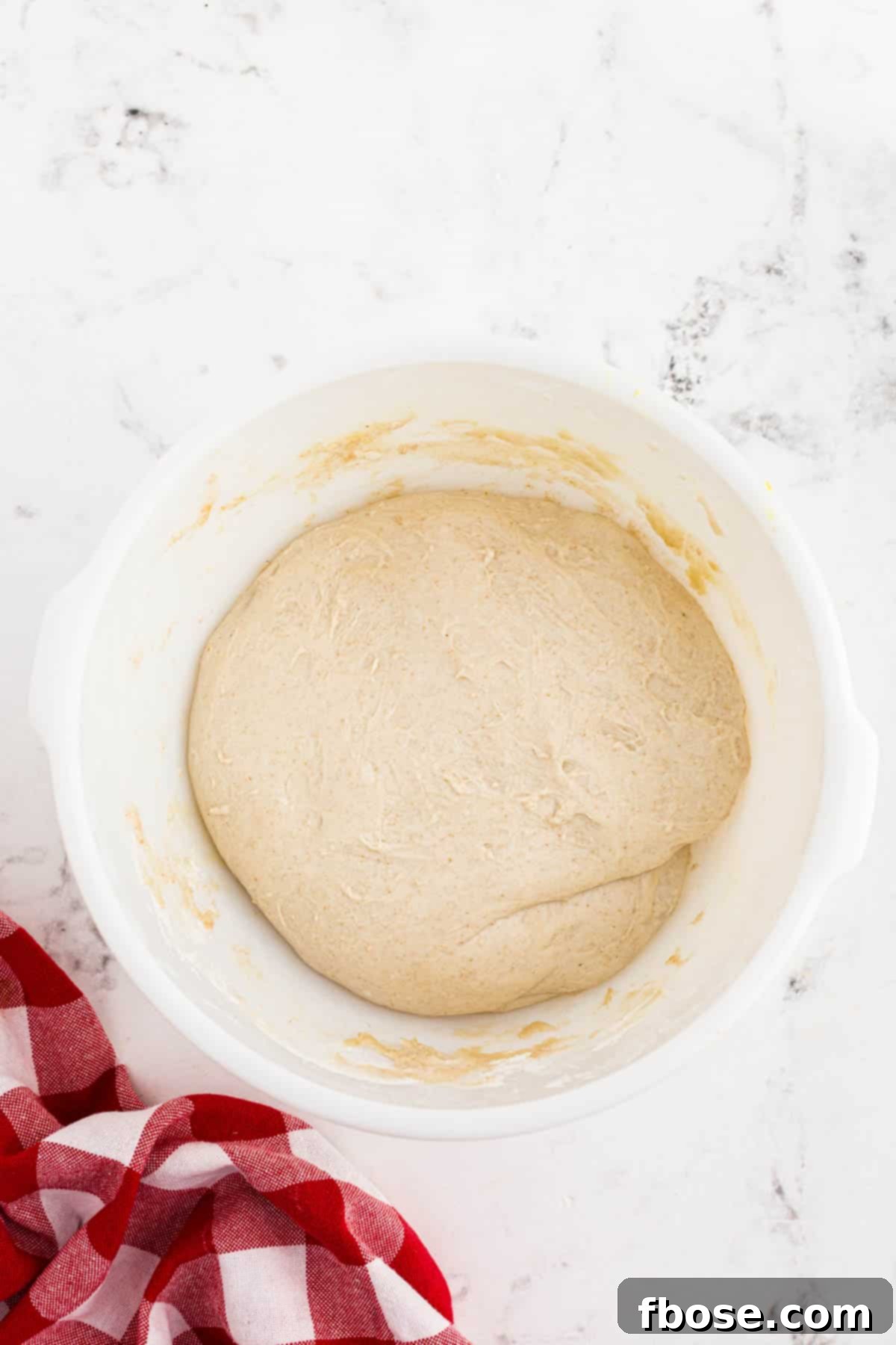Perfect Sourdough Pizza Dough 12 Sourdough pizza dough actively proofing and visibly expanded in a white bowl, indicating successful bulk fermentation.