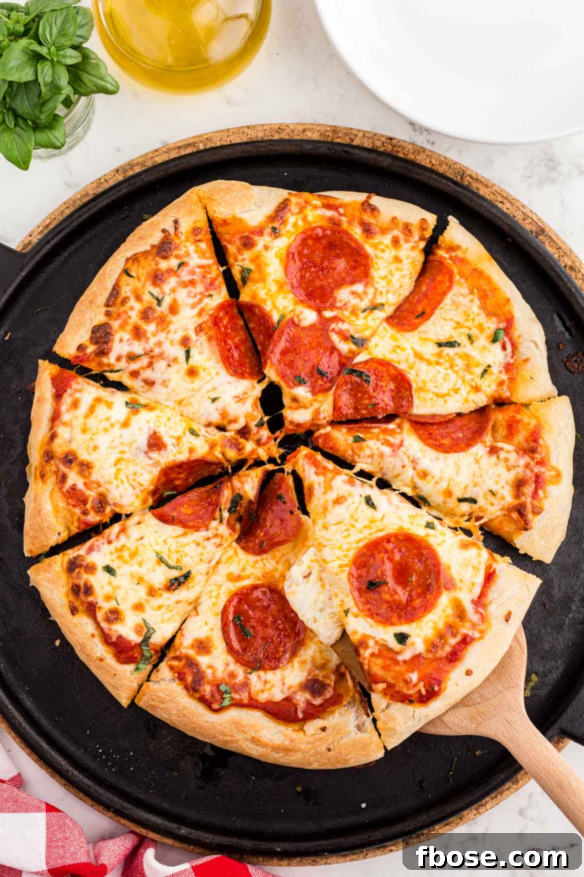 Perfect Sourdough Pizza Dough 17 Overhead shot of a beautifully baked sourdough pizza, perfectly sliced and ready to serve on a pizza stone, showcasing its golden crust and delicious toppings.