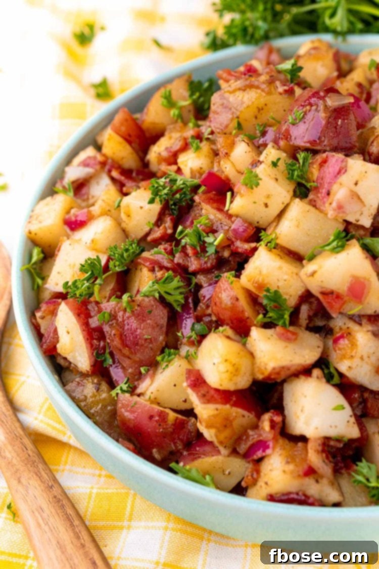 Close up photo of a teal bowl with German potato salad in it.