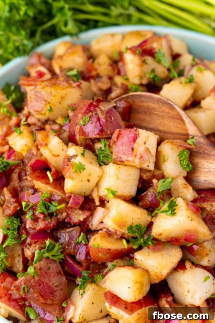 Close up photo of a bowl of German potato salad with a wooden spoon scooping some out.