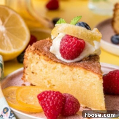 A slice of lemon olive oil cake on a pink plate on a yellow surface.