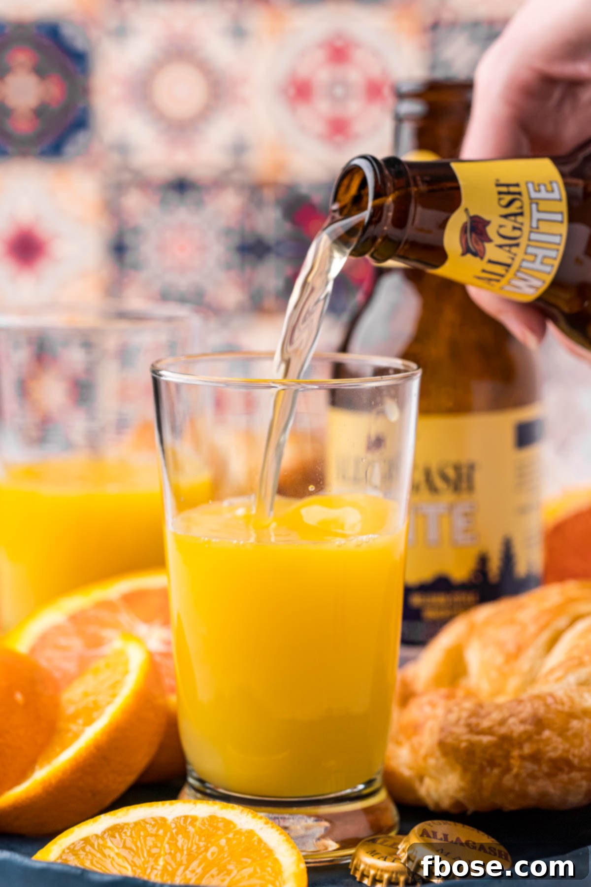 A bottle of beer being poured into a glass with orange juice, illustrating the simple preparation process.