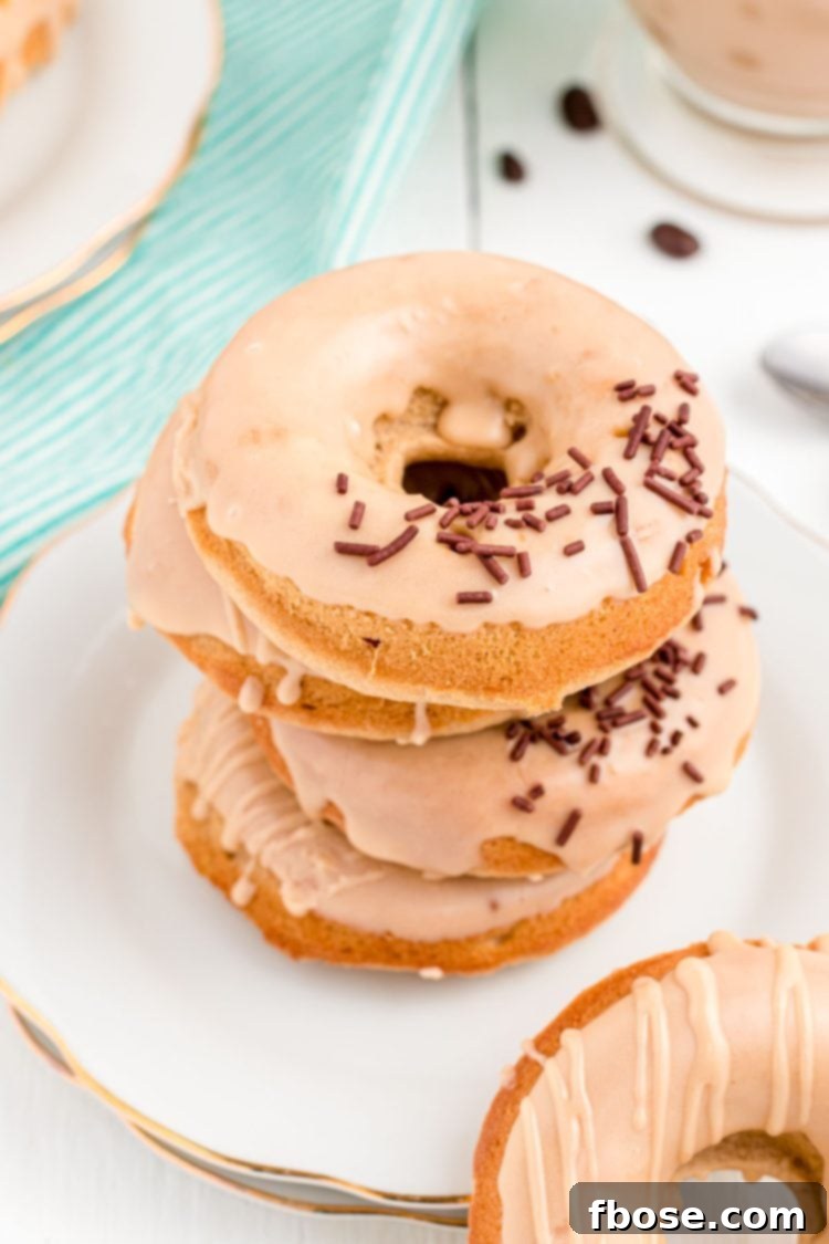 Brewed & Baked 2 Close up photo of coffee donuts stacked on top of each other on a white plate, showcasing their rich coffee glaze and inviting texture.
