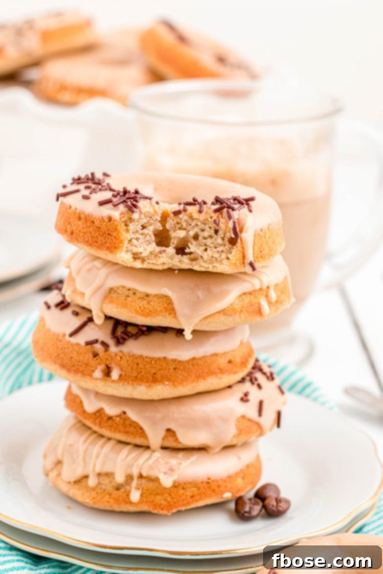 Brewed & Baked 3 Photo of a stack of 5 glazed coffee donuts on a white plate, ready to be enjoyed as a delightful breakfast or dessert.