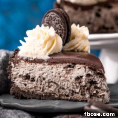 Close-up photo of a slice of no bake oreo cheesecake on a gray plate with oreos around it.