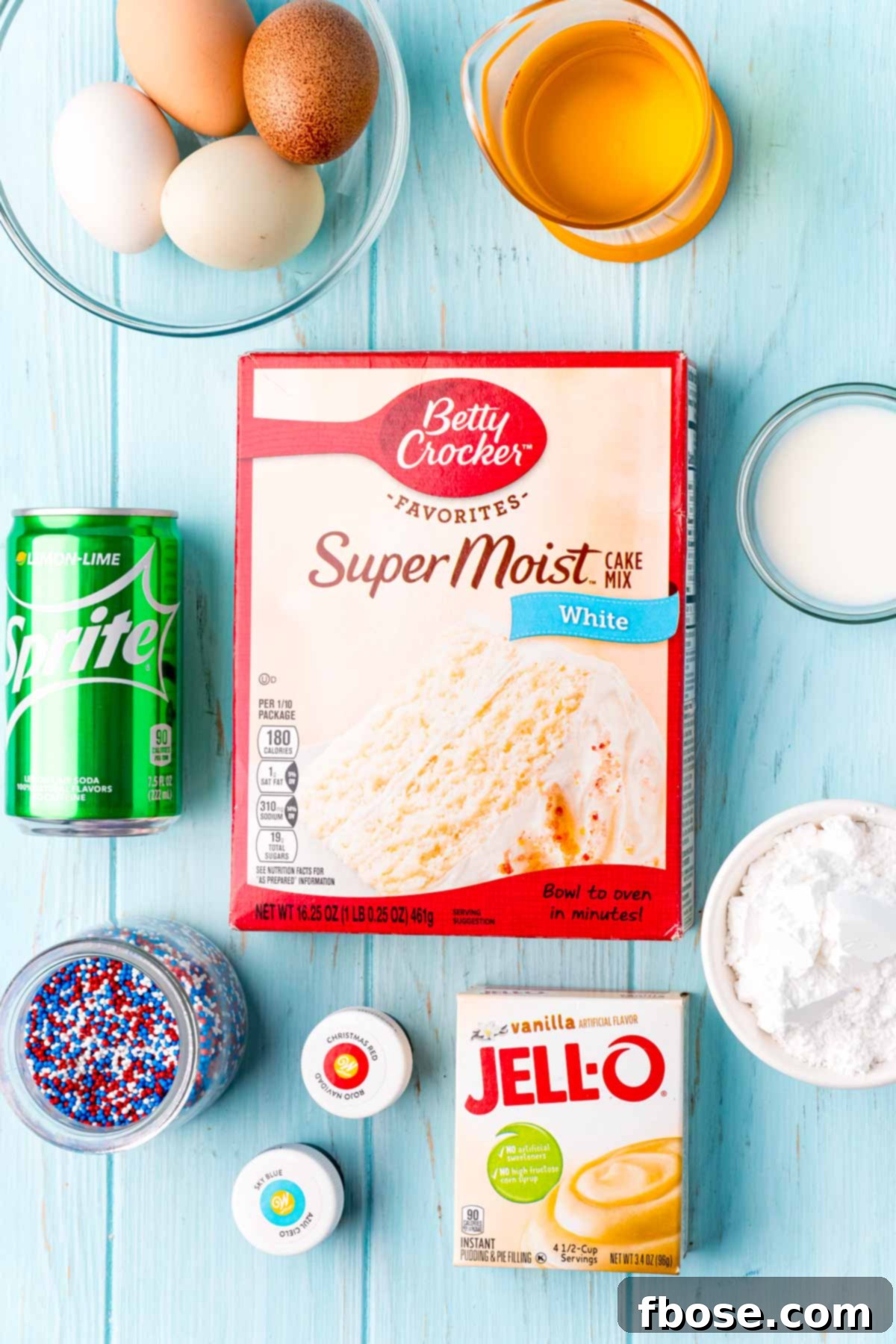 Overhead photo of ingredients used to make 4th of july sprite cake laid out on a blue wooden table, ready for preparation.