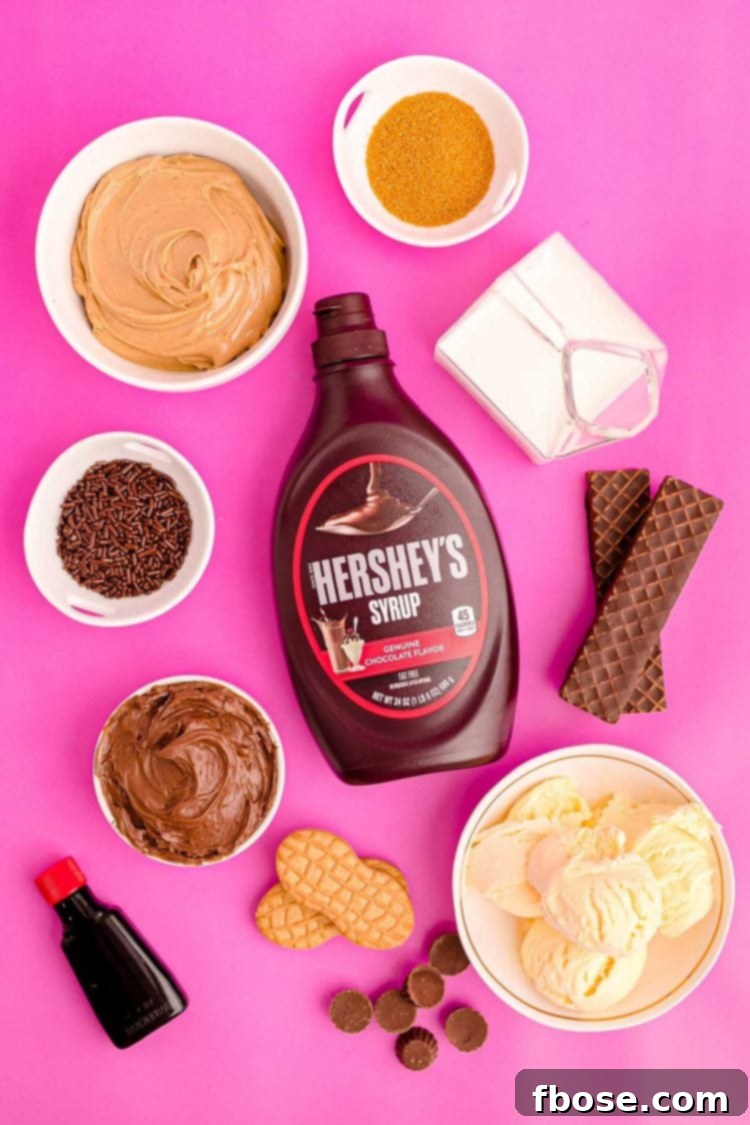 Peanut Butter Freakshake 4 Overhead photo of ingredients to make peanut butter milkshake (freak shake) on a pink surface surrounded by sweet toppings.