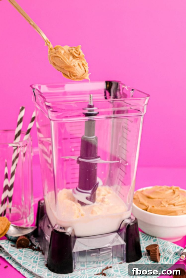 Peanut Butter Freakshake 5 A scoop of peanut butter being added to a blender with milk and ice cream to make a peanut butter milkshake.