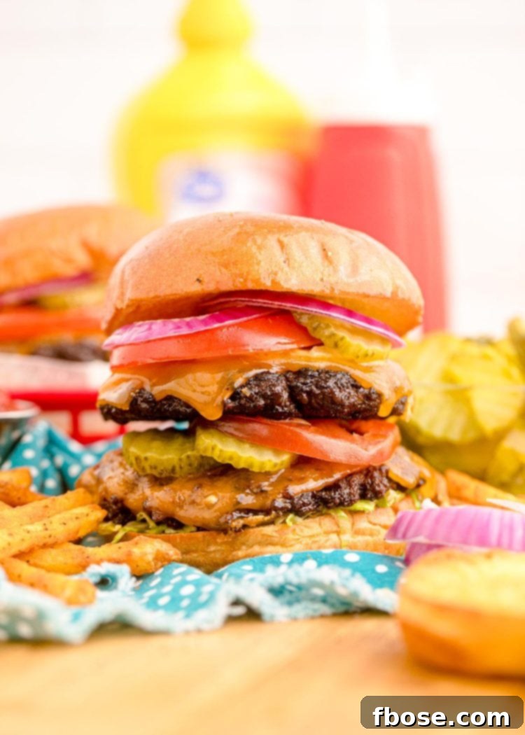 Close up of a smash burger on a blue napkin with condiment bottles in the background.
