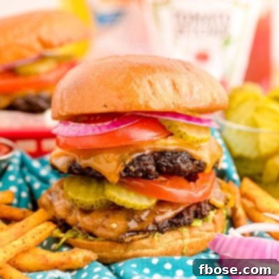Close up of a smash burger on a blue napkin with condiment bottles in the background.