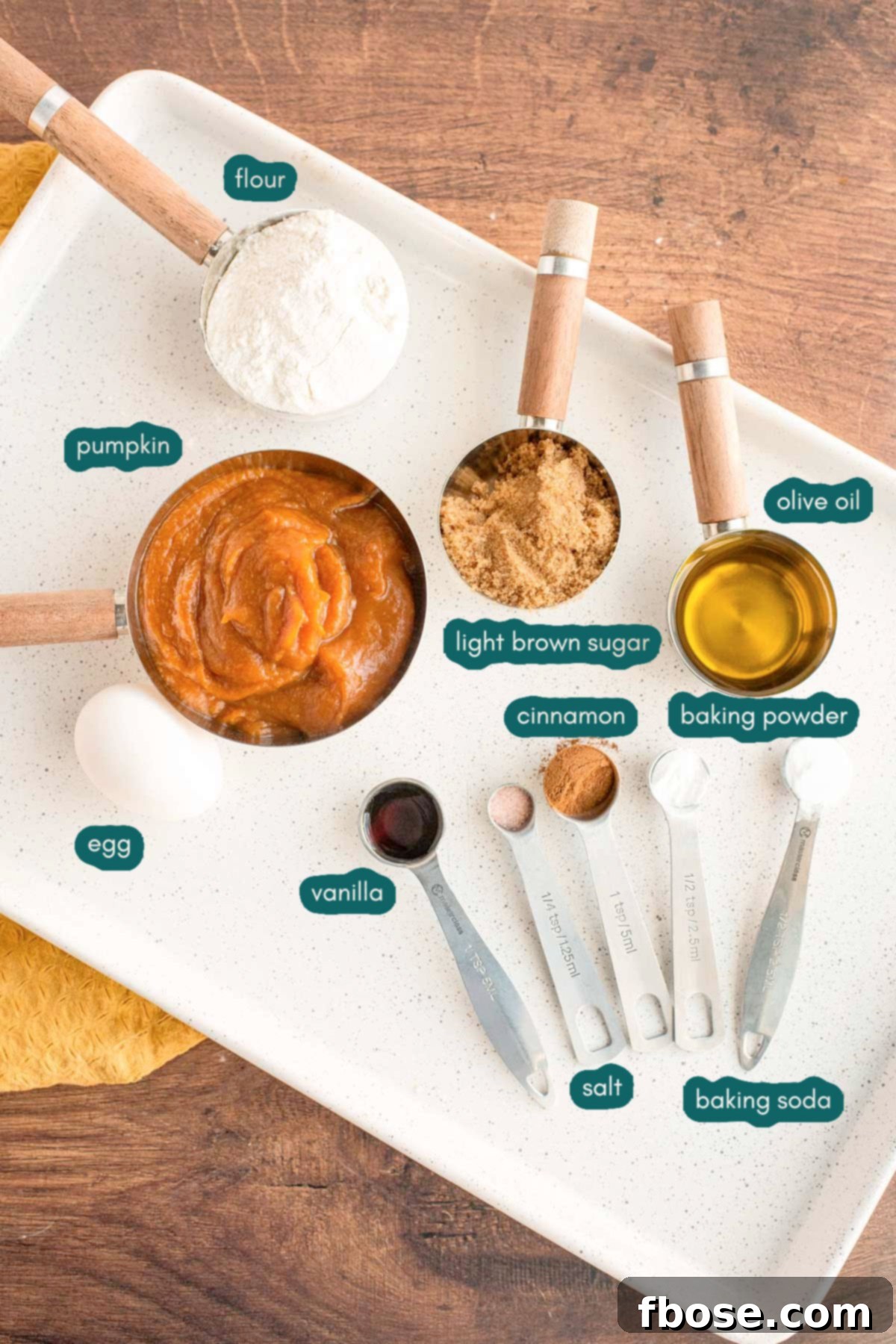 Overhead photo of ingredients to make pumpkin whoopie pies prepared on a white plate on a wooden table.