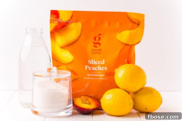 Ingredients to make peach lemonade on a white table.