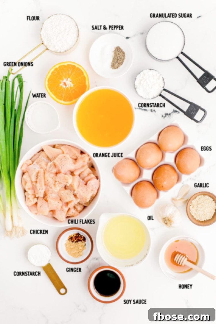 Overhead photo of ingredients to make orange chicken prepared on a marble counter.