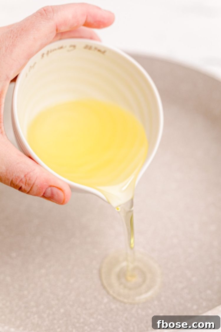 Oil being poured into a skillet.