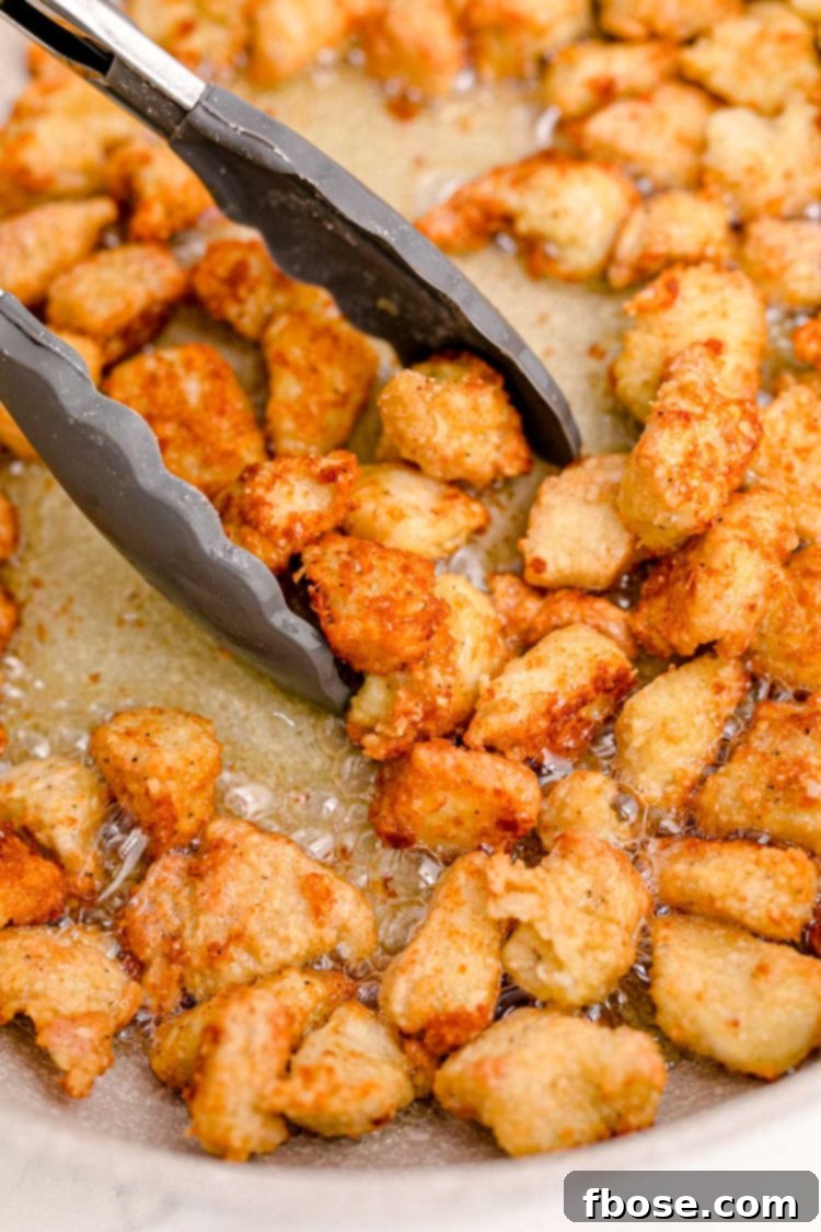 Chicken being cooked in a skillet.