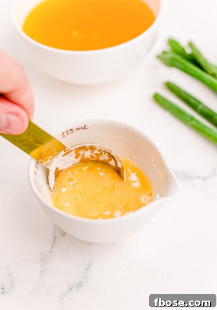 Orange juice and cornstarch mixed together in a small white bowl.
