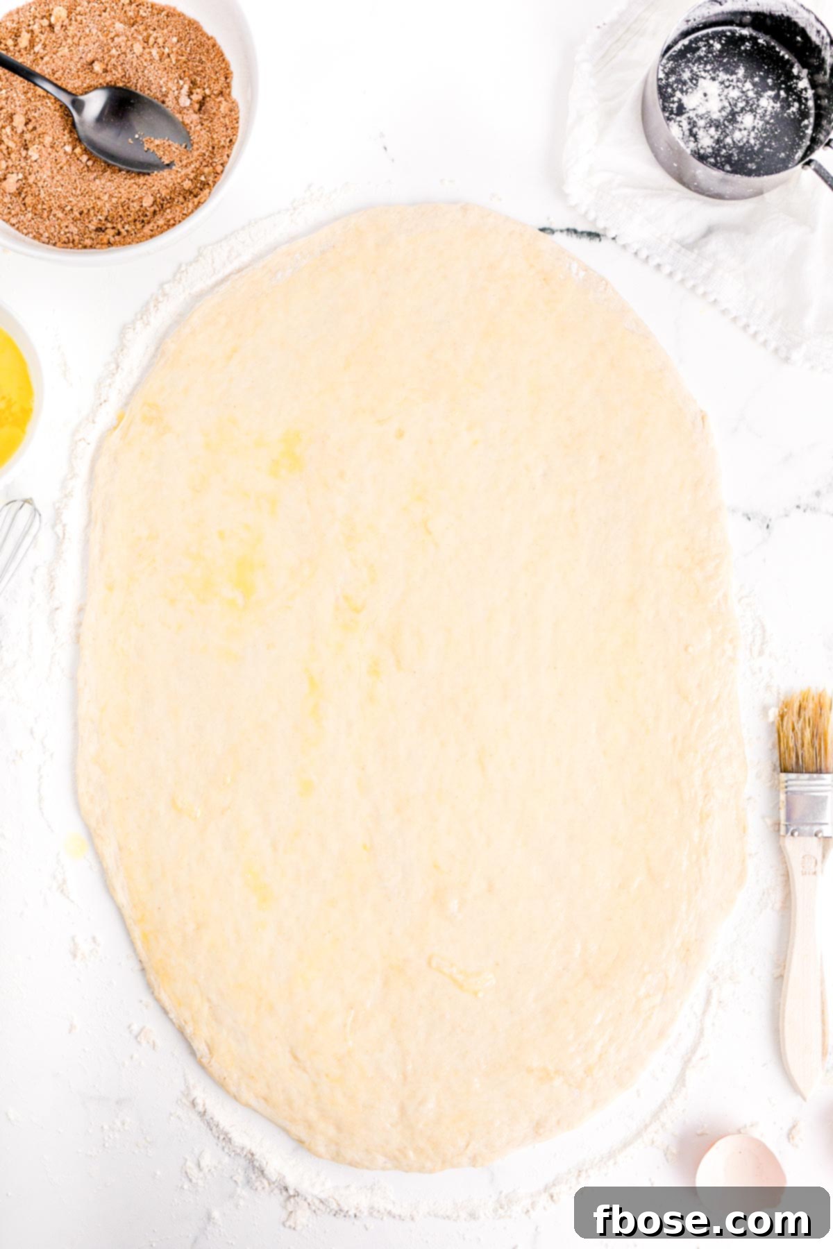 bread dough rolled out with egg wash brushed on.