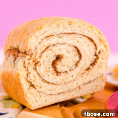 Close up photo of a loaf of cinnamon swirl bread that has been sliced into revealing the center.