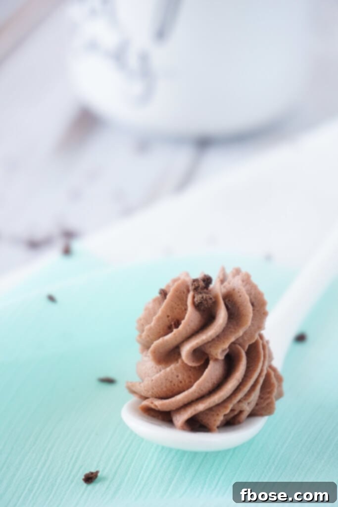 This Whipped Mocha Frosting is light, fluffy, and has a perfect balance of rich chocolate and bold coffee. Creamy, airy mocha frosting piped onto cupcakes, garnished with chocolate shavings.