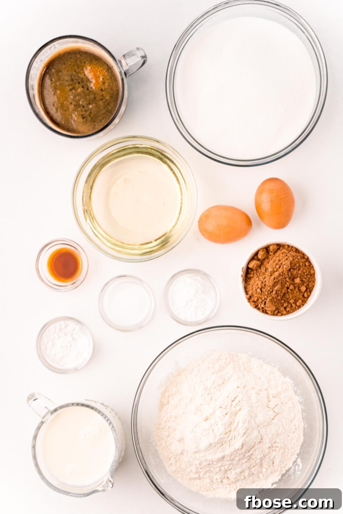 Overhead photo of all the carefully prepped ingredients for Nana's Devil's Food Cake, arranged on a pristine white table.