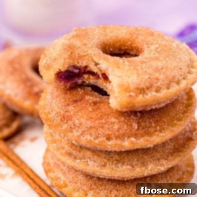 Viral Uncrustables Donut Hack 7 Close up photo of a stack of Uncrustables donuts on a white tray with the top one missing a bite.