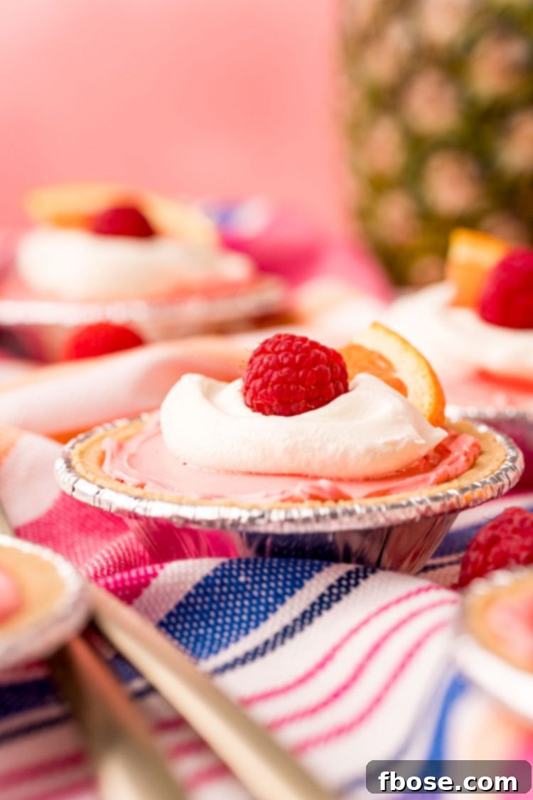 Close up photo of a mini kool-aid pie on a pink, white, and blue striped napkin. 