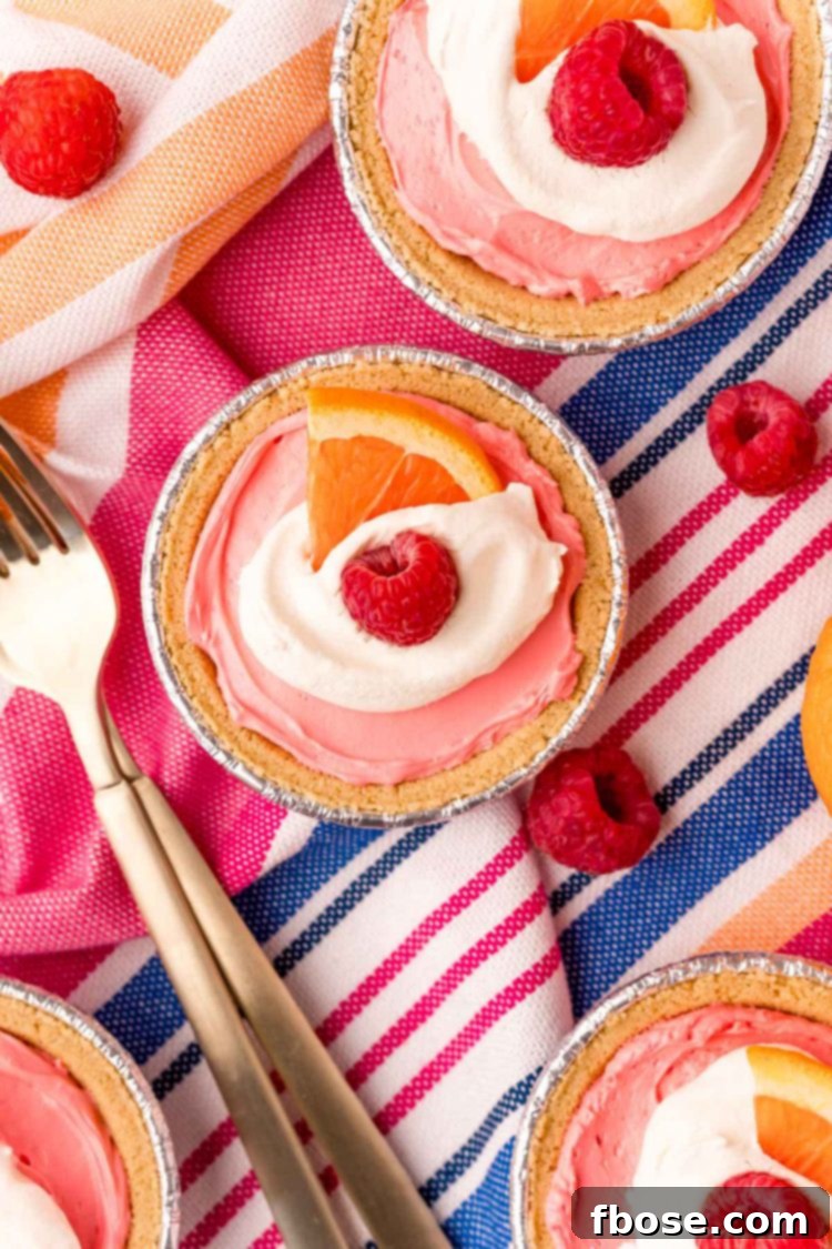 Overhead photo of mini kool aid pies on a blue, pink, and white striped napkin.