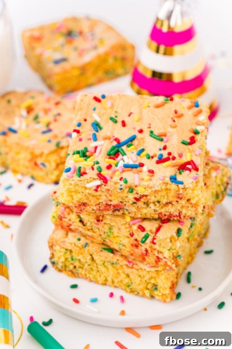 Close up photo of cake mix brownies on a white plate on a white table surrounded by sprinkles and birthday hats.