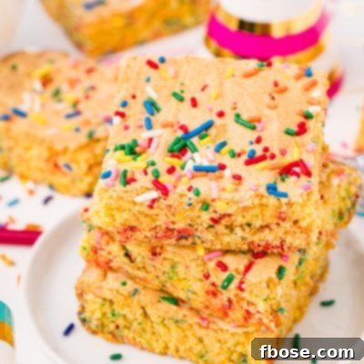 Close up photo of cake mix brownies on a white plate on a white table surrounded by sprinkles and birthday hats.