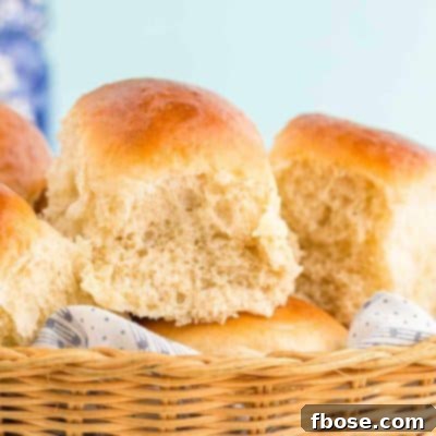Close up photo of sourdough discard dinner rolls in a basket.