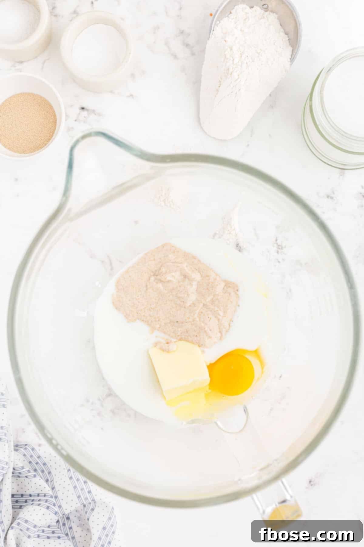 Buttermilk, softened butter, an egg, and sourdough discard in a mixing bowl, ready to be combined.