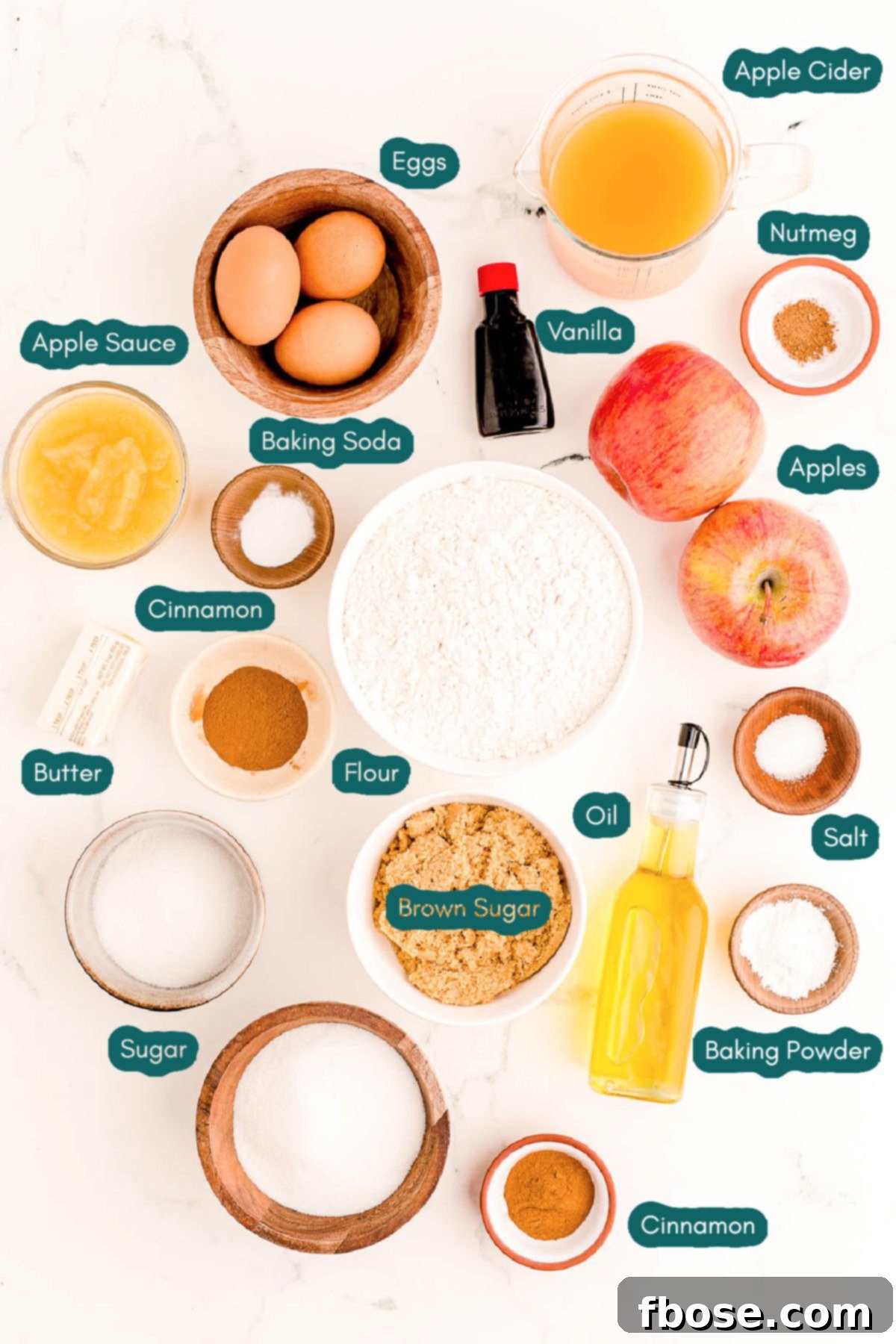 Overhead photo of ingredients to prepare apple cider donut cake on a marble surface.