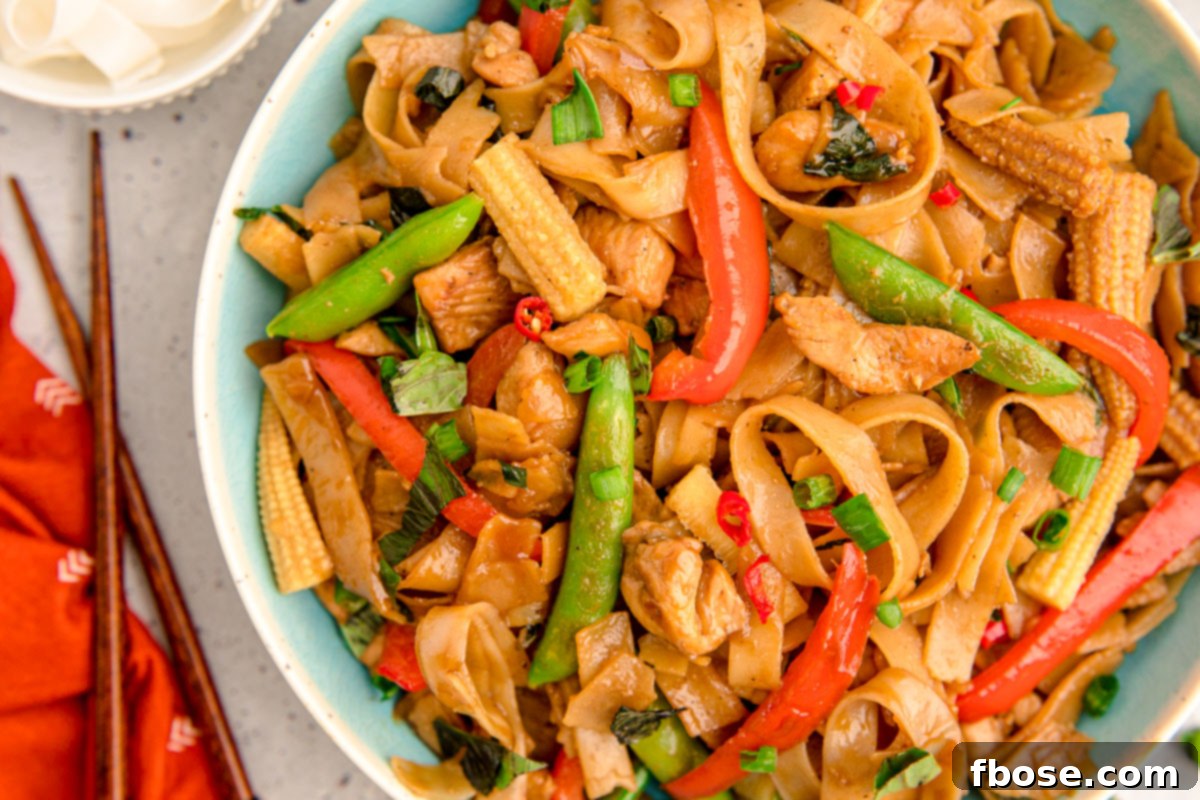 A generous serving of Drunken Noodles in a blue bowl, showcasing its delicious texture and ingredients.