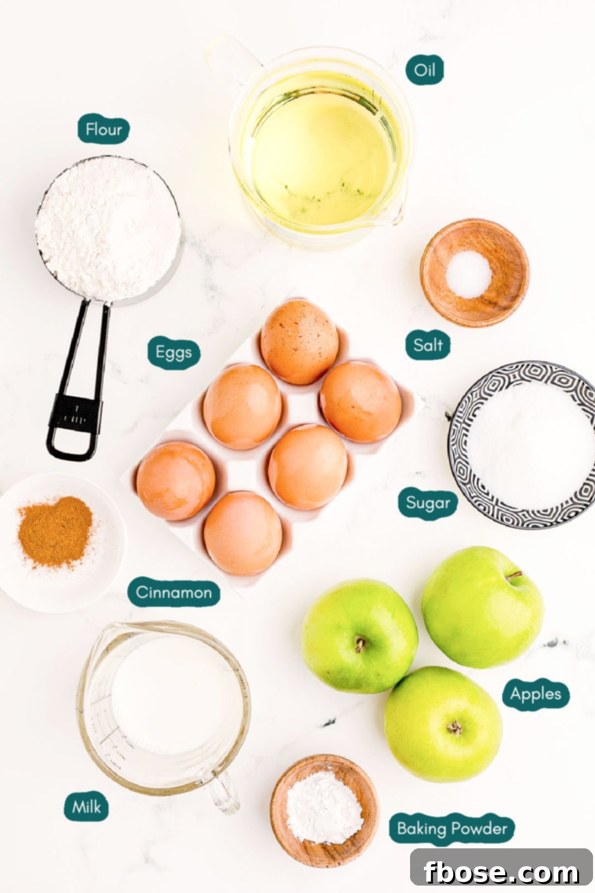 Overhead photo of ingredients to make homemade apple fritters on a marble table.