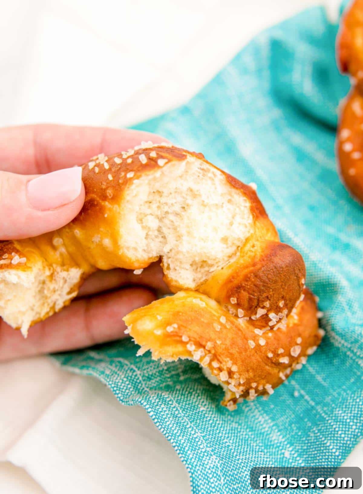 Close up of a soft pretzel ripped open, revealing its airy, fluffy interior texture.