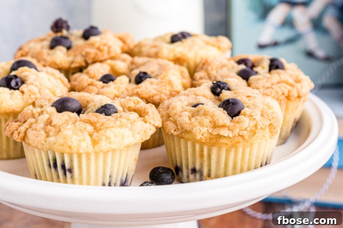 Sourdough blueberry muffins on a white cake stand.