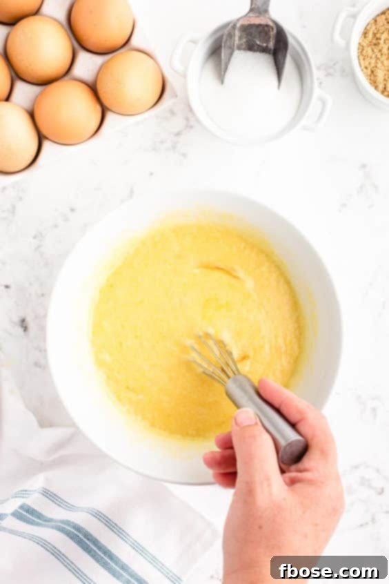 A woman's hand whisking ingredients in a mixing bowl.