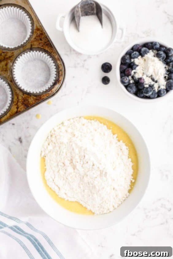 Overhead photo of a mixing bowl with dry ingredients being added to wet.